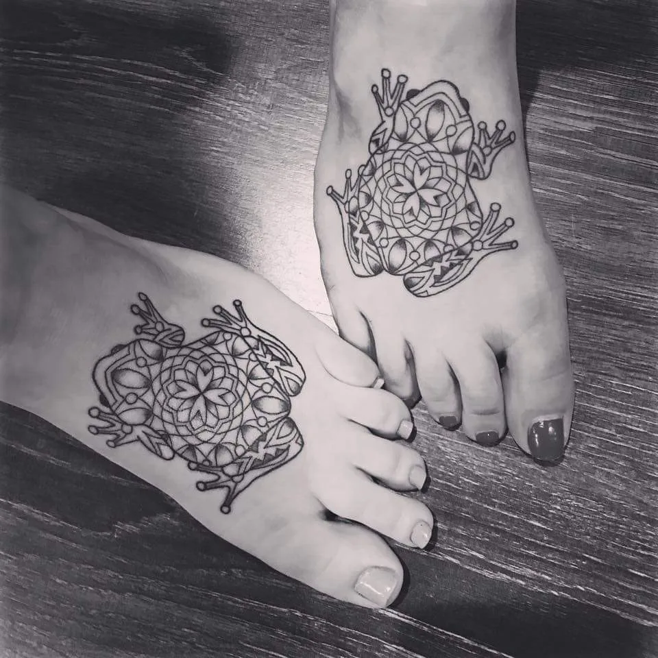 Black Line Work Elaborate Twin Frog Tattoo On Foot
