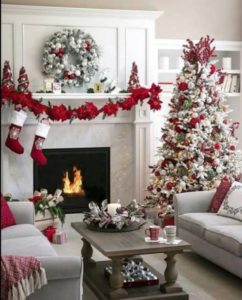 White Christmas tree decorated with red ornaments, red garland and wreath perfect for Christmas living room decoration.