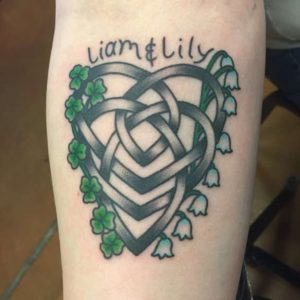 Celtic tattoo decorated with flowers and leaves for good luck.