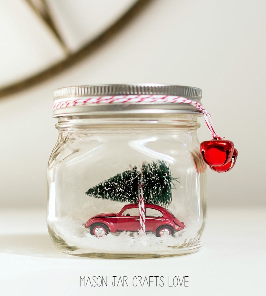 Car carrying Christmas tree in mason jar snow globe.