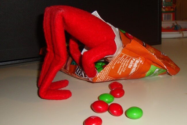 Elf caught eating from a bag of M & M.