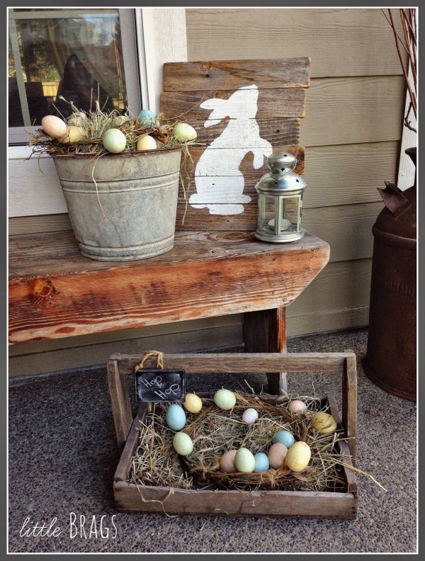 Reclaimed woodne tray used as birds nest with pastel eggs, grapevine wreath and bunny sign board.