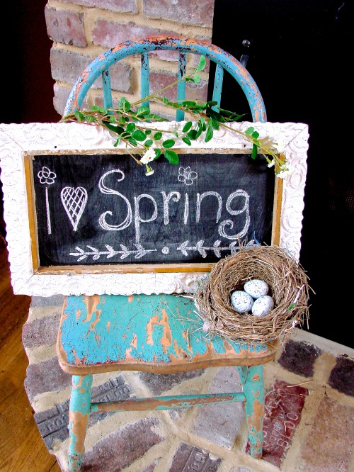 Upcycled frame chalkboard placed on a reclaimed wooden chair and add some greenery and a small birds nest.